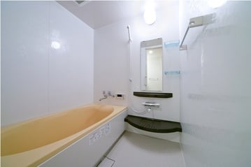 広い浴室に暖かい色合いの浴槽でゆったりバスタイムを過ごせます